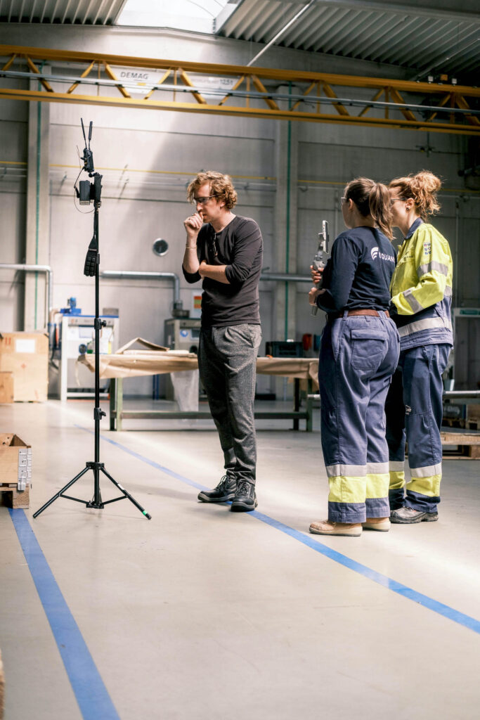 Regisseur en Equans medewerker in overall bespreken scène op locatie