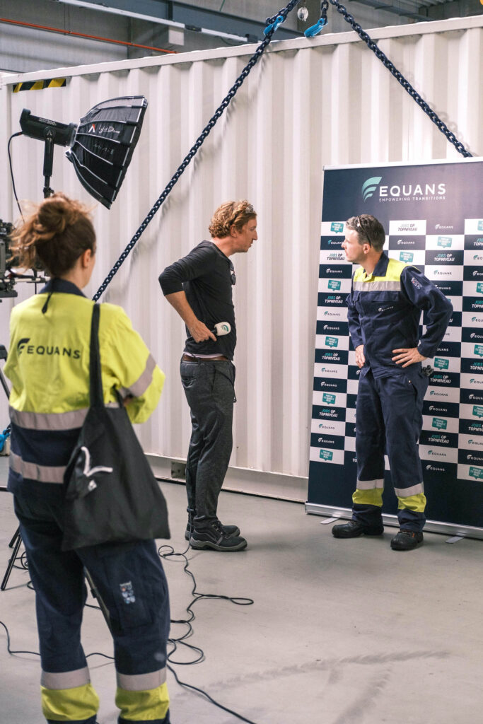 Equans medewerker in geel hesje staat klaar voor opname bij industriële ingang