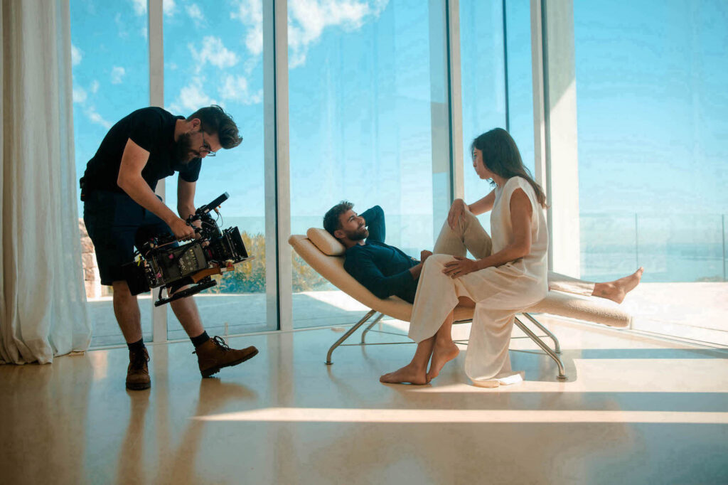Model zit op designzetel in lichte villa, behind the scenes Fiqa Textiles brand video