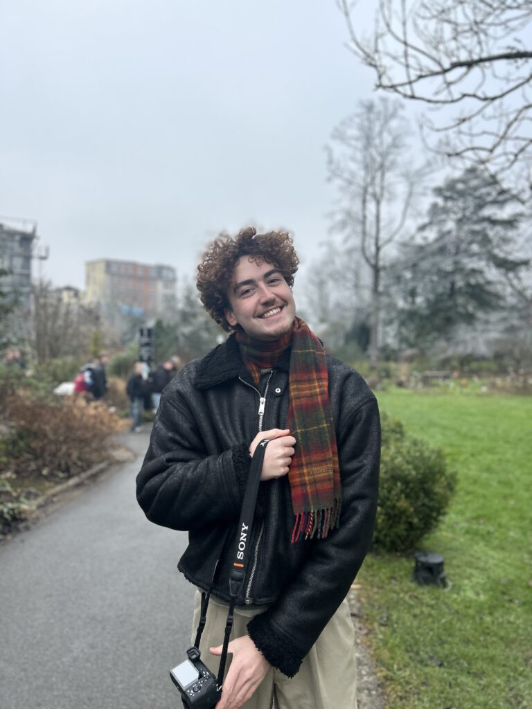 Cameravrouw met camera poseert glimlachend buiten bij het GUM