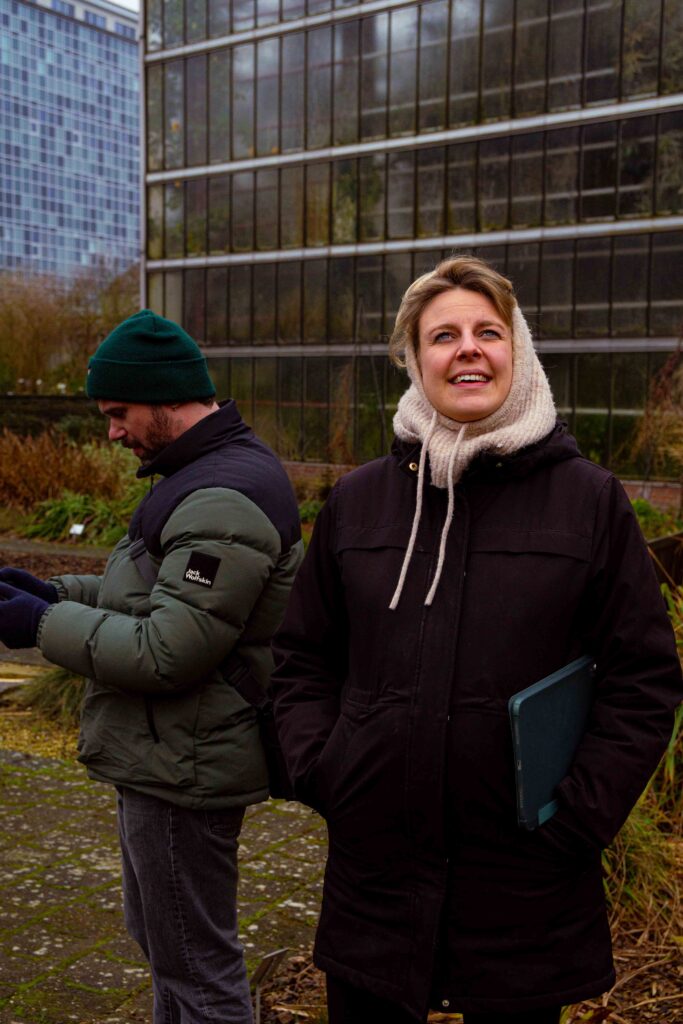 Cameraman met groene muts en camera in buitenomgeving, behind the scenes GUM