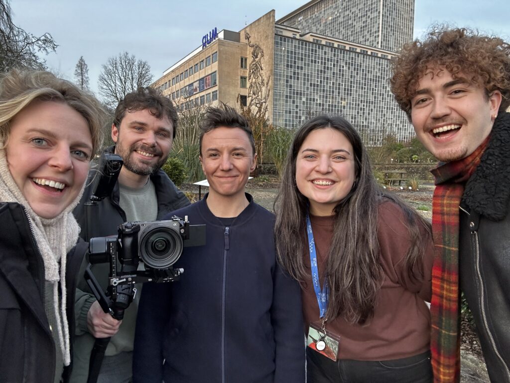 Het Peloton cameraploeg poseert samen buiten voor opnames GUM